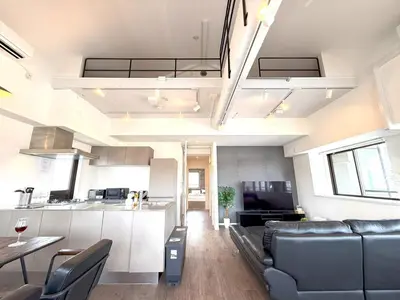 a living room and kitchen with a couch and a table at 東京最上階の豪邸ステイ 最上階270度ビュー&スカイツリーを望む 最大8名貸切 上野浅草秋葉原近く 無料WiFi アルカディア北千住 in Tokyo