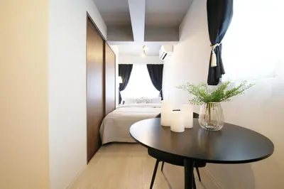 a small room with a table and a bed at Heureux\u690e\u540d\u753a202 in Tokyo