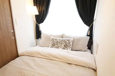a bed in a small room with a window at Heureux\u690e\u540d\u753a202 in Tokyo