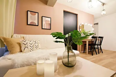 a living room with a couch and a table with a vase at Relax Family Inn IKEBUKURO in Tokyo