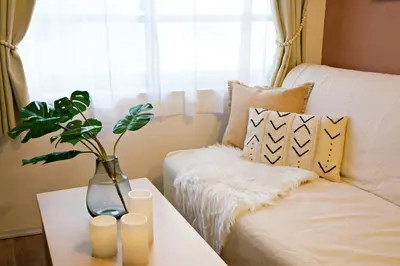 a vase on a table next to a couch with candles at Relax Family Inn IKEBUKURO in Tokyo