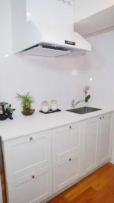 a kitchen with white cabinets and a sink at LIO HOTEL Tokyo Nippori in Tokyo