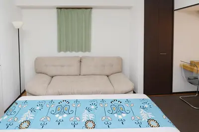 a living room with a bed and a couch at LIO HOTEL Tokyo Nippori in Tokyo