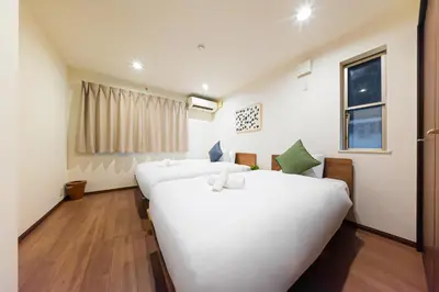 a room with two beds and a window at Starry Stay House Shibuya I in Tokyo