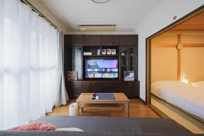 a bedroom with a bed and a tv and a table at Asakusa 2BR Apt Kitchen 8P \u6d45\u83492LDK \u30ad\u30c3\u30c1\u30f3\u4ed8 \u6700\u59278\u540d in Tokyo