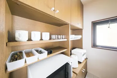 a small kitchen with wooden shelves and white dishes at Asakusa 2BR Apt Kitchen 8P \u6d45\u83492LDK \u30ad\u30c3\u30c1\u30f3\u4ed8 \u6700\u59278\u540d in Tokyo
