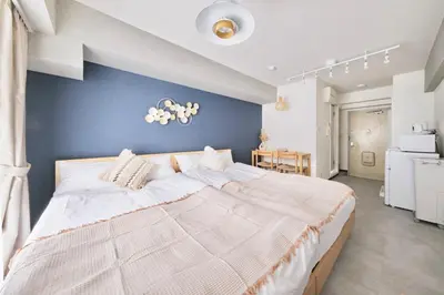 a bedroom with a large bed with a blue wall at Pet\u767e\u4eba\u753a1\u4e01\u76ee202 in Tokyo