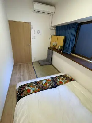 a small room with a bed and a window at \u9280\u5ddd\u306e\u5bbf in Tokyo