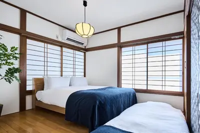 a bedroom with two beds and large windows at \u3077\u3075\u304b\u548c\u83dc\u9418\u30f6\u6df5 in Tokyo