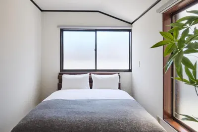 a bedroom with a bed and a window at \u3077\u3075\u304b\u548c\u83dc\u9418\u30f6\u6df5 in Tokyo