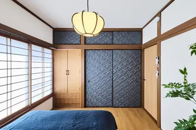 a bedroom with a blue bed and a glass door at \u3077\u3075\u304b\u548c\u83dc\u9418\u30f6\u6df5 in Tokyo