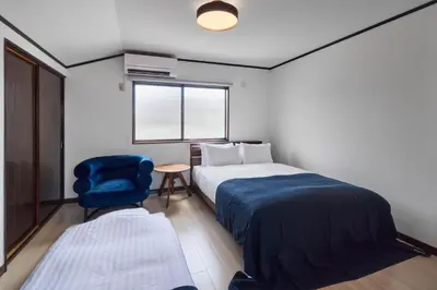 a bedroom with a bed and a chair and a window at \u3077\u3075\u304b\u548c\u83dc\u9418\u30f6\u6df5 in Tokyo