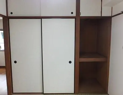 a closet with two white doors and wooden shelves at Shinjuku Okubo Henna House in Tokyo