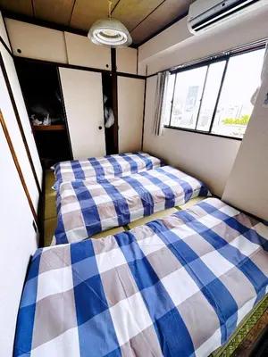 two beds in the back of a room at Shinjuku Okubo Henna House in Tokyo