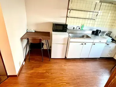 a small kitchen with a sink and a table at Shinjuku Okubo Henna House in Tokyo