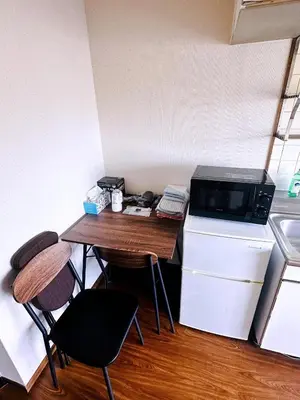 a small kitchen with a table and a microwave at Shinjuku Okubo Henna House in Tokyo