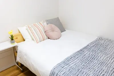 a bedroom with a white bed with a pink pillow at -Shibamata House- 9-minute walk from Shibamata Station in Tokyo
