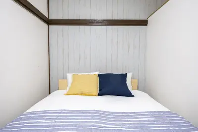 a bed with a yellow and blue pillow on it at -Shibamata House- 9-minute walk from Shibamata Station in Tokyo