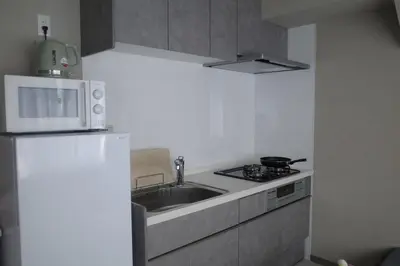 a kitchen with a sink and a white refrigerator at \u30ea\u30cb\u30e5\u30fc\u30a2\u30eb\u6e08 \u4e0a\u91ce\u79cb\u8449\u539f\u8fd1\u304f\u6700\u59275\u4eba\u5bbf\u6cca\u53ef in Tokyo