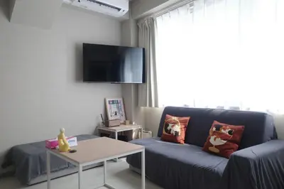 a living room with a couch and a tv at \u30ea\u30cb\u30e5\u30fc\u30a2\u30eb\u6e08 \u4e0a\u91ce\u79cb\u8449\u539f\u8fd1\u304f\u6700\u59275\u4eba\u5bbf\u6cca\u53ef in Tokyo