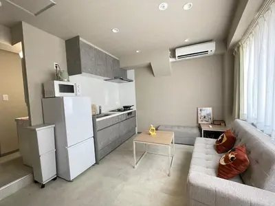 a kitchen and a living room with a white refrigerator at \u30ea\u30cb\u30e5\u30fc\u30a2\u30eb\u6e08 \u4e0a\u91ce\u79cb\u8449\u539f\u8fd1\u304f\u6700\u59275\u4eba\u5bbf\u6cca\u53ef in Tokyo