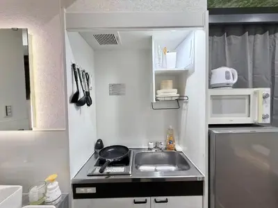 a small kitchen with a sink and a microwave at \u30af\u30ea\u30b9\u30bf\u30eb\u9ad8\u7530\u99ac\u5834101 in Tokyo