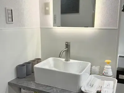 a white sink in a bathroom with a mirror at \u30af\u30ea\u30b9\u30bf\u30eb\u9ad8\u7530\u99ac\u5834101 in Tokyo