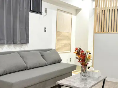 a living room with a couch and a table with flowers at \u30af\u30ea\u30b9\u30bf\u30eb\u9ad8\u7530\u99ac\u5834 201 in Tokyo