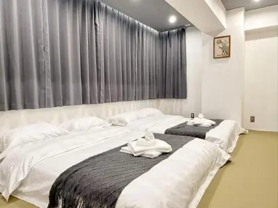 two beds with towels on them in a bedroom at \u30af\u30ea\u30b9\u30bf\u30eb\u9ad8\u7530\u99ac\u5834 201 in Tokyo