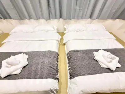 two beds with white sheets and towels on them at \u30af\u30ea\u30b9\u30bf\u30eb\u9ad8\u7530\u99ac\u5834 301 in Tokyo