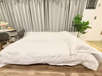 a bedroom with a white bed and a table at \u30af\u30ea\u30b9\u30bf\u30eb\u9ad8\u7530\u99ac\u5834 401 in Tokyo