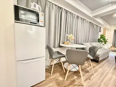 a kitchen with a white refrigerator and a table with chairs at \u30af\u30ea\u30b9\u30bf\u30eb\u9ad8\u7530\u99ac\u5834 401 in Tokyo