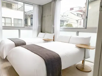 two beds in a room with a window at 201Room,7-minute walk from Uguisudani Station located on the 2nd floor of an apartment-style building Twin room No elevator in Tokyo