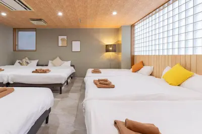 a room with four beds with white sheets at Spacious Private Hotel Floor for up to 16 Guests about 10 minute walk from JR Ryogoku Station HOTEL Musashi Tokyo Ryogoku in Tokyo
