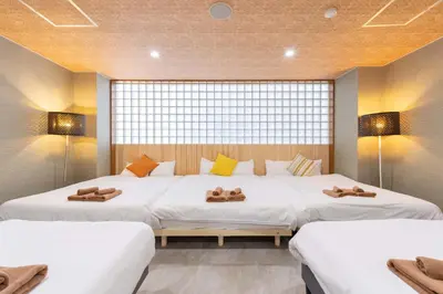 two beds in a room with two lamps and two bedsitures at Spacious Private Hotel Floor for up to 16 Guests about 10 minute walk from JR Ryogoku Station HOTEL Musashi Tokyo Ryogoku in Tokyo
