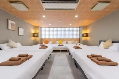 a row of beds in a large room at Spacious Private Hotel Floor for up to 16 Guests about 10 minute walk from JR Ryogoku Station HOTEL Musashi Tokyo Ryogoku in Tokyo