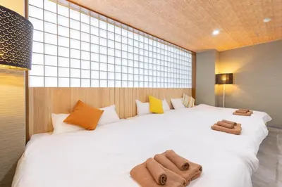 a bedroom with a large white bed with towels on it at Spacious Private Hotel Floor for up to 16 Guests about 10 minute walk from JR Ryogoku Station HOTEL Musashi Tokyo Ryogoku in Tokyo