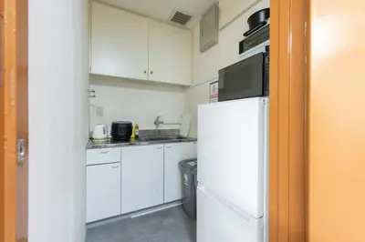 a kitchen with white cabinets and a refrigerator at Spacious Private Hotel Floor for up to 16 Guests about 10 minute walk from JR Ryogoku Station HOTEL Musashi Tokyo Ryogoku in Tokyo