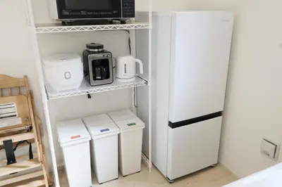 a small kitchen with a refrigerator and a microwave at Skytree Neighbors close to Asakusa & Tokyo Skytree in Tokyo