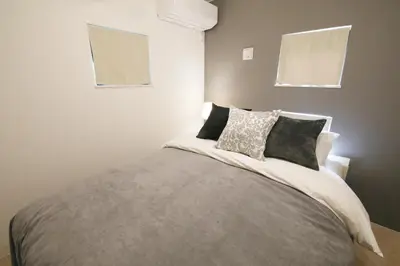 a bedroom with a large bed with two windows at Skytree Neighbors close to Asakusa & Tokyo Skytree in Tokyo