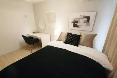 a bedroom with a black and white bed and a chair at Skytree Neighbors close to Asakusa & Tokyo Skytree in Tokyo