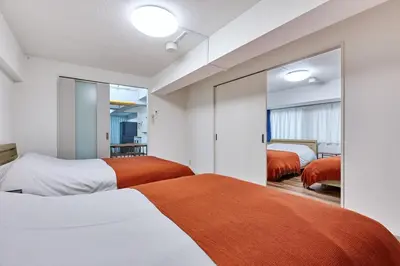 a bedroom with two beds and a mirror at G&R House Premium in Tokyo