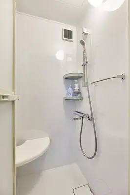 a white bathroom with a shower and a sink at G&R House Premium in Tokyo