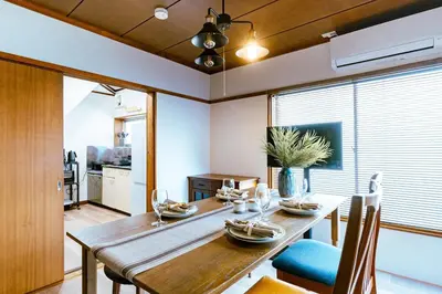 a dining room with a wooden table and chairs at 1ST BASE ICHINOE 3BR House 13 Guests Disney 30min NRT Bus in Tokyo