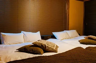 two beds with pillows on them in a bedroom at 1ST BASE ICHINOE 3BR House 13 Guests Disney 30min NRT Bus in Tokyo