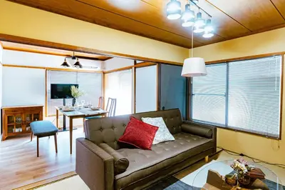 a living room with a couch and a table at 1ST BASE ICHINOE 3BR House 13 Guests Disney 30min NRT Bus in Tokyo