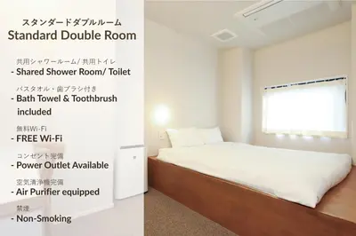 a bedroom with a bed with a sign on the wall at E10 Hostel in Tokyo