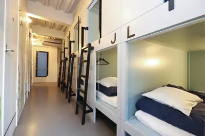 a hallway with a row of bunk beds at E10 Hostel in Tokyo