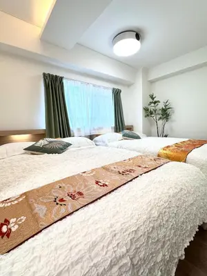 two beds in a bedroom with a window at Motosakura 401 Asakusa Ueno Akihabara Area, Bicycle Rental, 6 Minutes to Station, 2 Simmons Beds, Elevator, Direct Access to Airport in Tokyo
