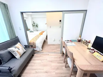 a room with a couch and a table and a mirror at Motosakura 401 Asakusa Ueno Akihabara Area, Bicycle Rental, 6 Minutes to Station, 2 Simmons Beds, Elevator, Direct Access to Airport in Tokyo